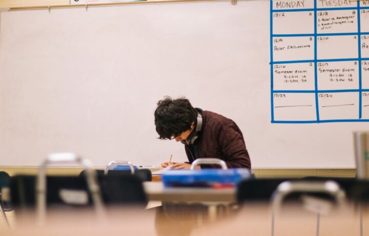 Illustrative student writing in a classroom, not a photograph from a Netanya school