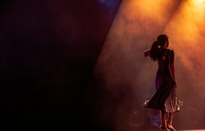 Illustration: dancers performing on a lit stage; not a photograph of the Netanya Aliyah Day event