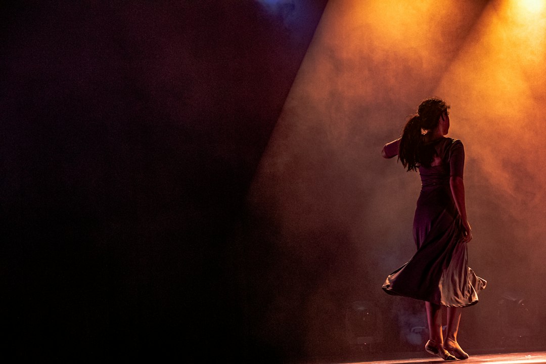 Illustration: dancers performing on a lit stage; not a photograph of the Netanya Aliyah Day event