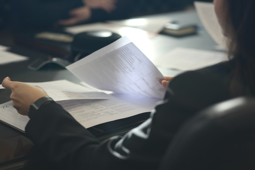 Illustration: a woman reviewing documents at a table; not a photograph of the Netanya event