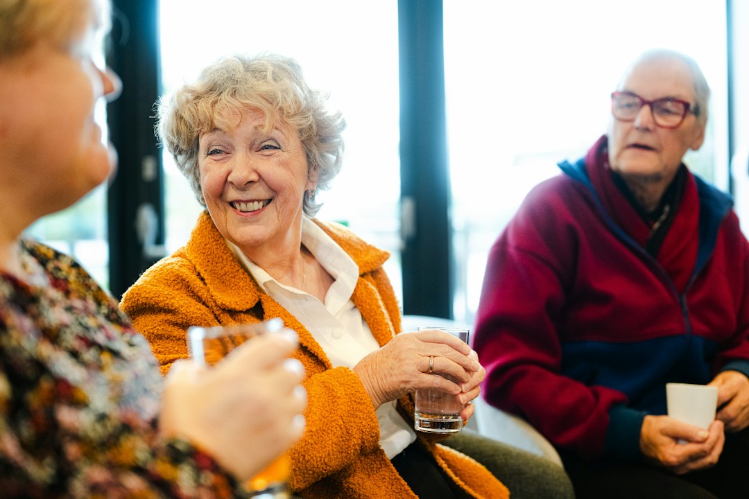 Illustrative stock photo of three senior adults talking at a community event; not a photograph of Netanya's 2026 Senior Citizens Month events. Photo: Centre for Ageing Better / Unsplash.